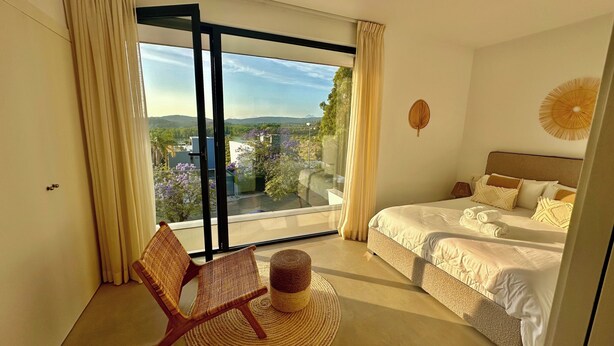 A bedroom with a large window, a bed, a chair, and a view of the outdoors. - Villa - Sleeps 8 - Near Beaches Golf and Polo (San Roque)