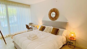 A hotel room with a bed, a desk, a chair, a lamp, and a window with curtains. - Villa - Sleeps 8 - Near Beaches Golf and Polo (San Roque)