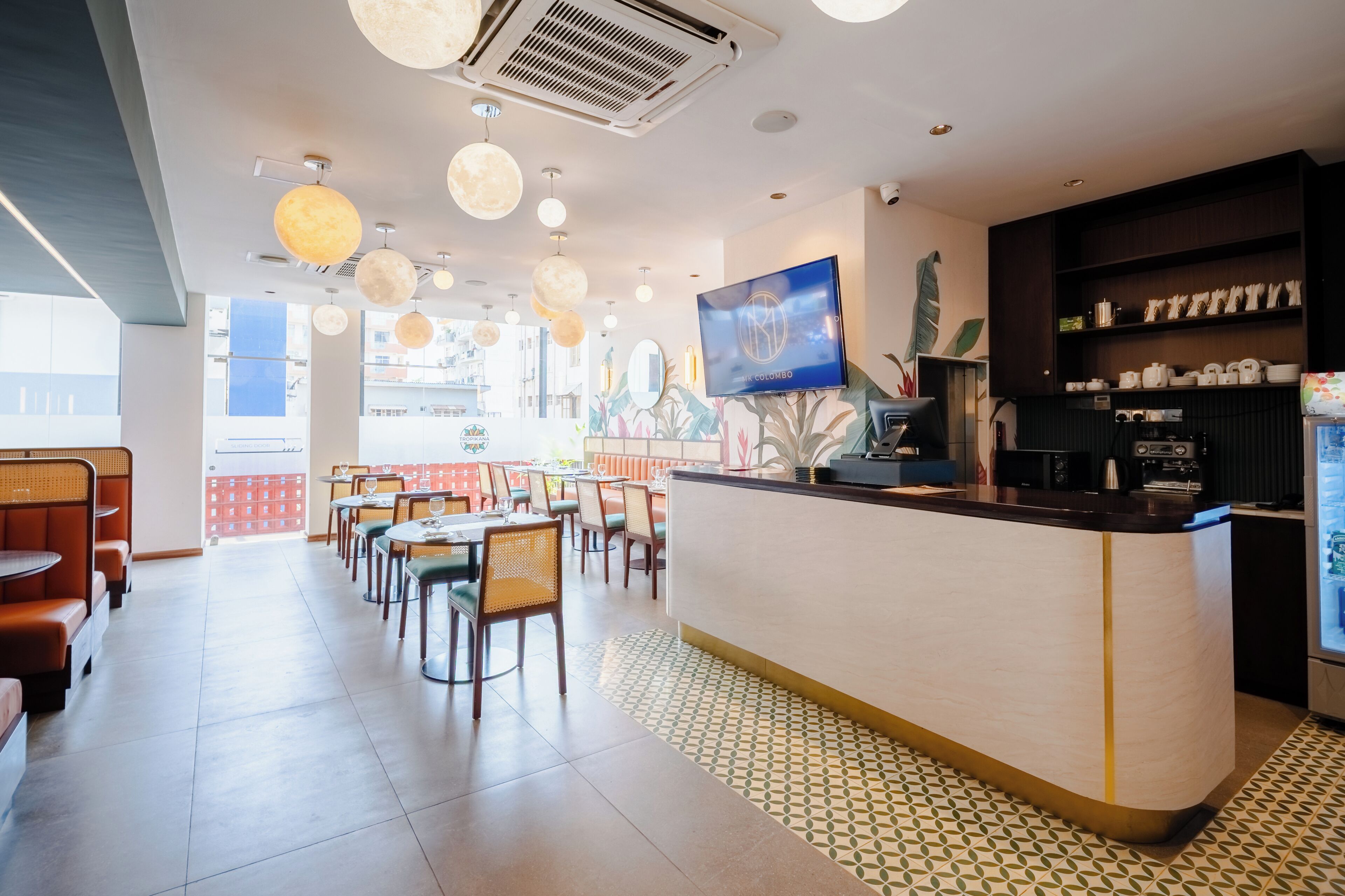Ein Restaurant mit einer Theke, Sitzbereich und dekorativen Deckenleuchten.