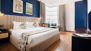 Une chambre d’hôtel moderne avec un grand lit, un bureau et une vue sur la ville.