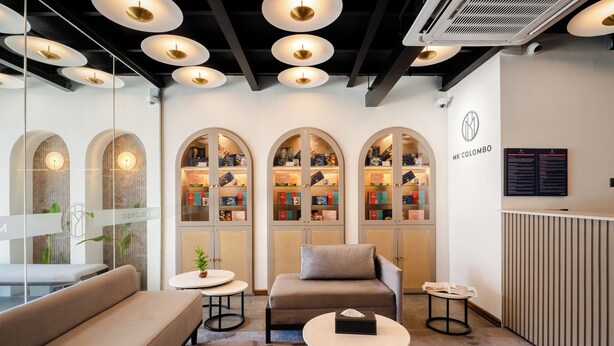 Un espace de détente moderne comprenant un canapé, une petite table, une bibliothèque et un comptoir d’accueil.