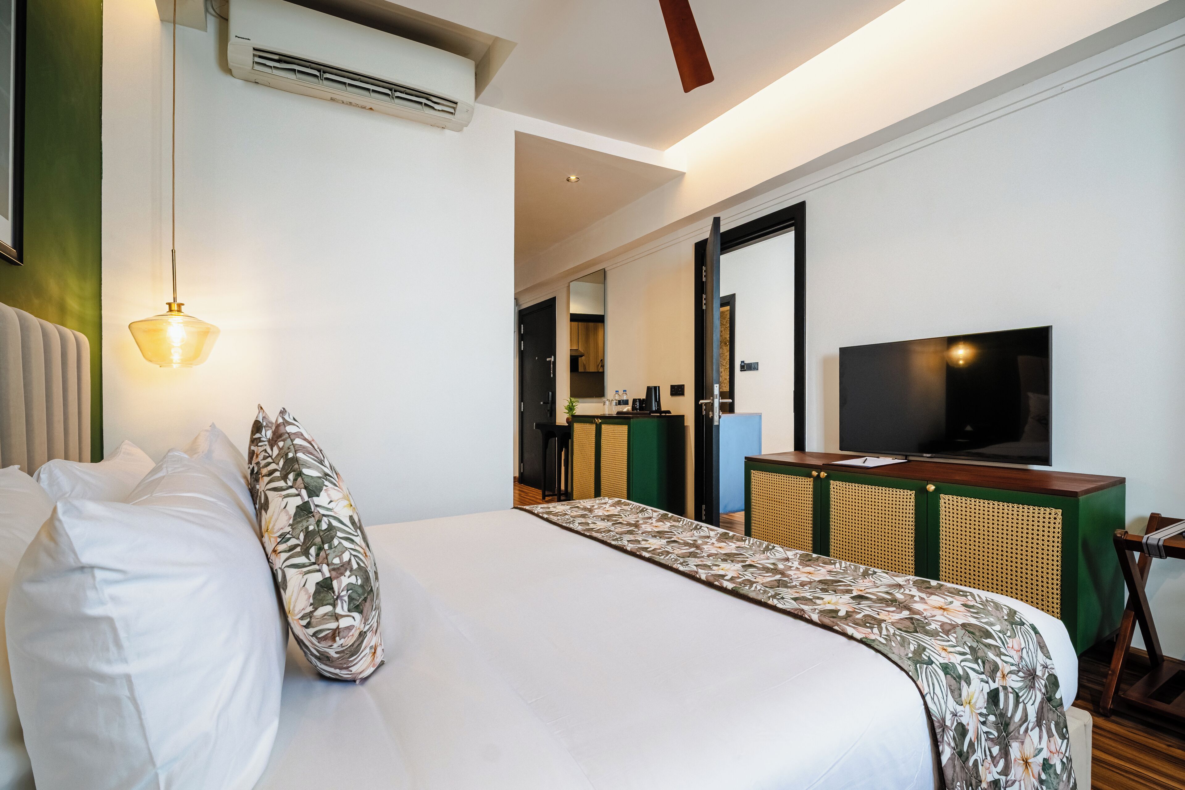A hotel room with a bed, a television, a desk, and a chair.