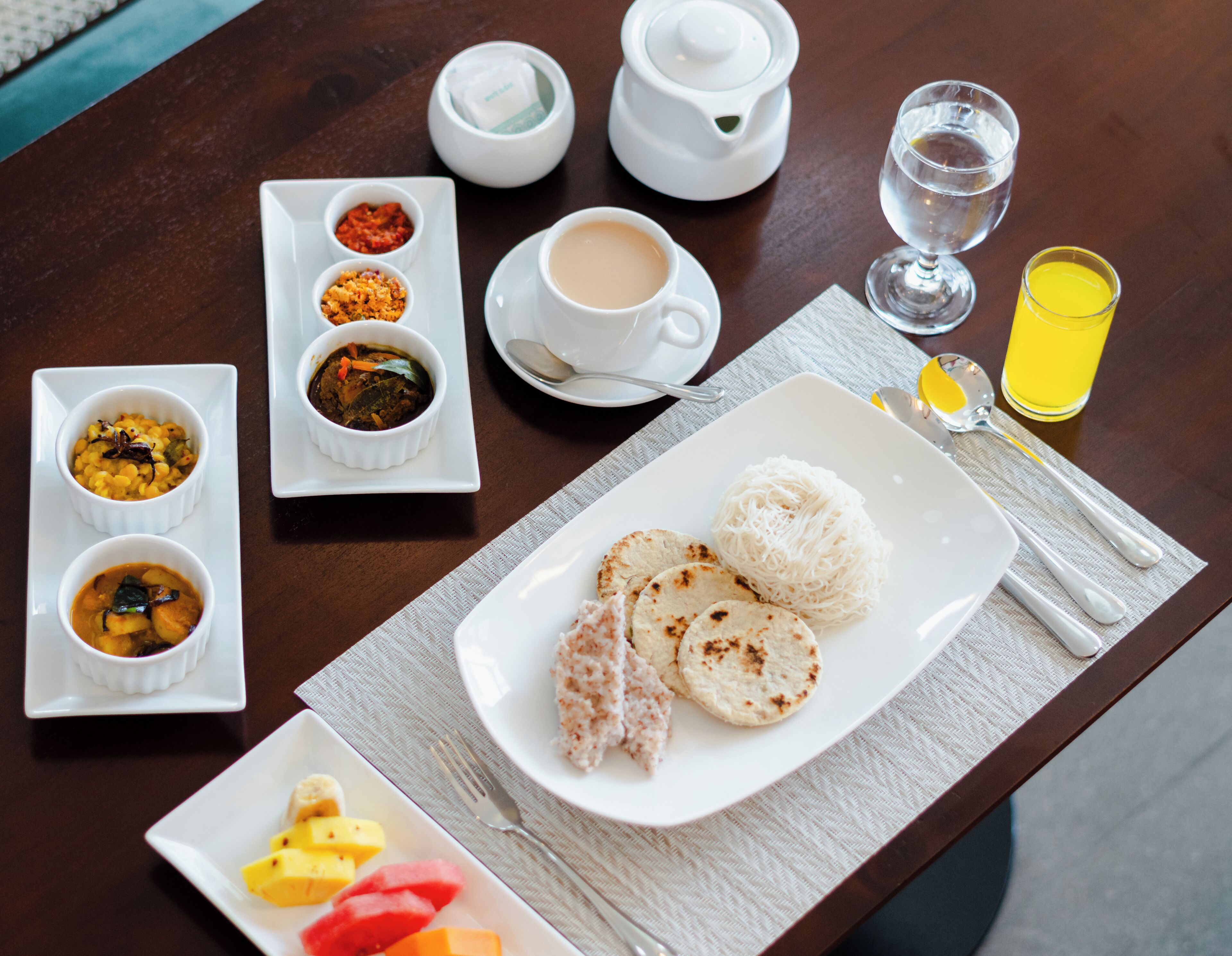Una mesa de comedor con varios platos, incluyendo arroz, sopa y fruta.