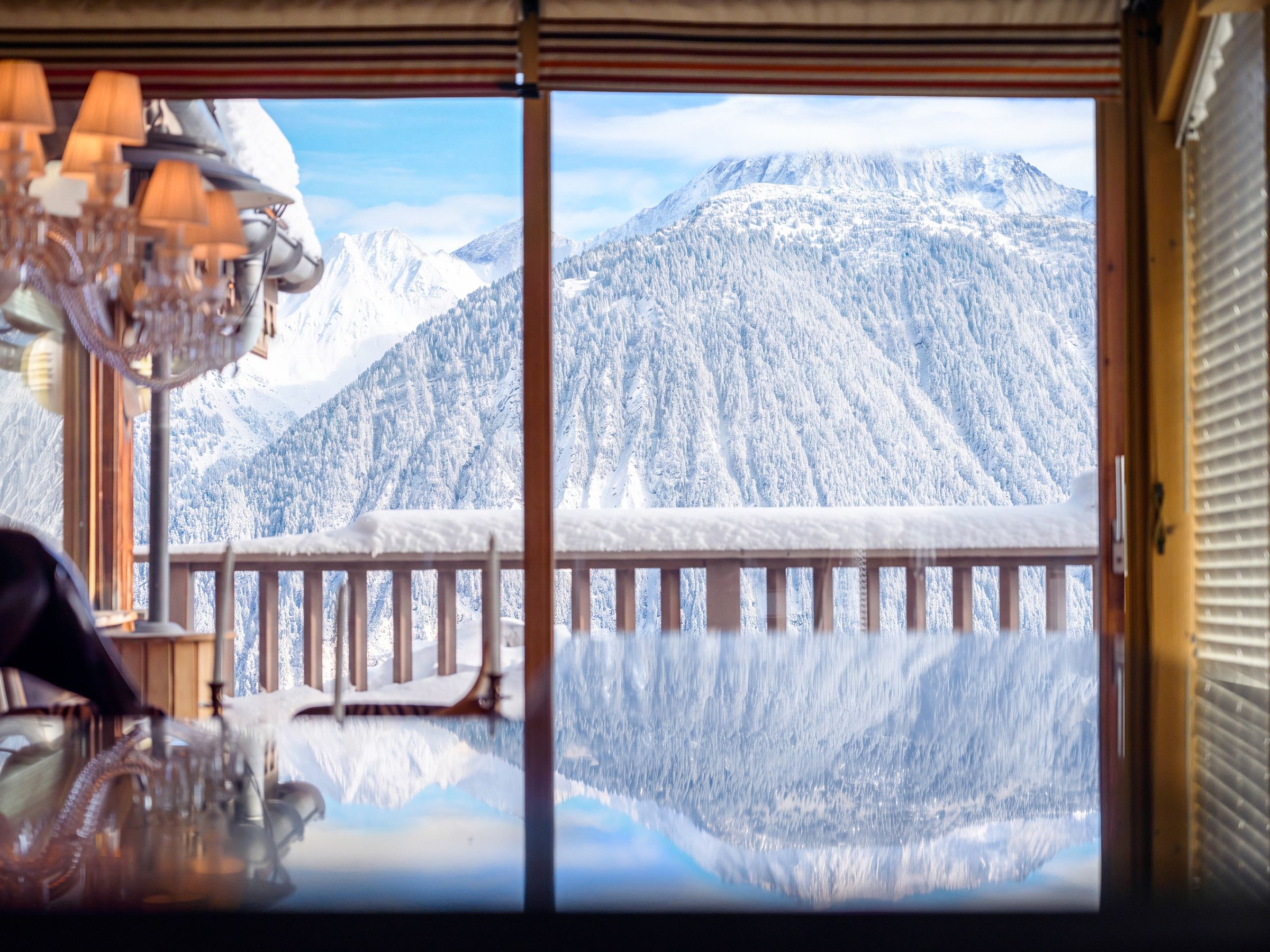Een kamer met uitzicht op met sneeuw bedekte bergen door een groot raam.