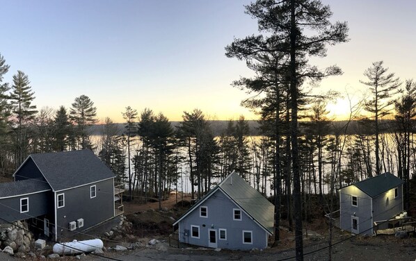 A residential area with houses near a body of water, surrounded by trees. - Impressive Cottage with Fire Pit and Lake Access in Orland, Maine (Orland)