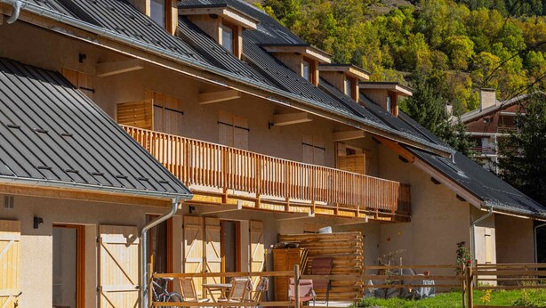 A chalet with a balcony, wooden railings, and a mountain backdrop. - Modern apartment in Monêtier, near the village (Le Monêtier-les-Bains)