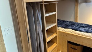 A bunk bed with a wooden headboard, a pull-out shelf, and a small storage space underneath. - Studio in Cernix, 4 pers, near slopes, large terrace (Crest-Voland)
