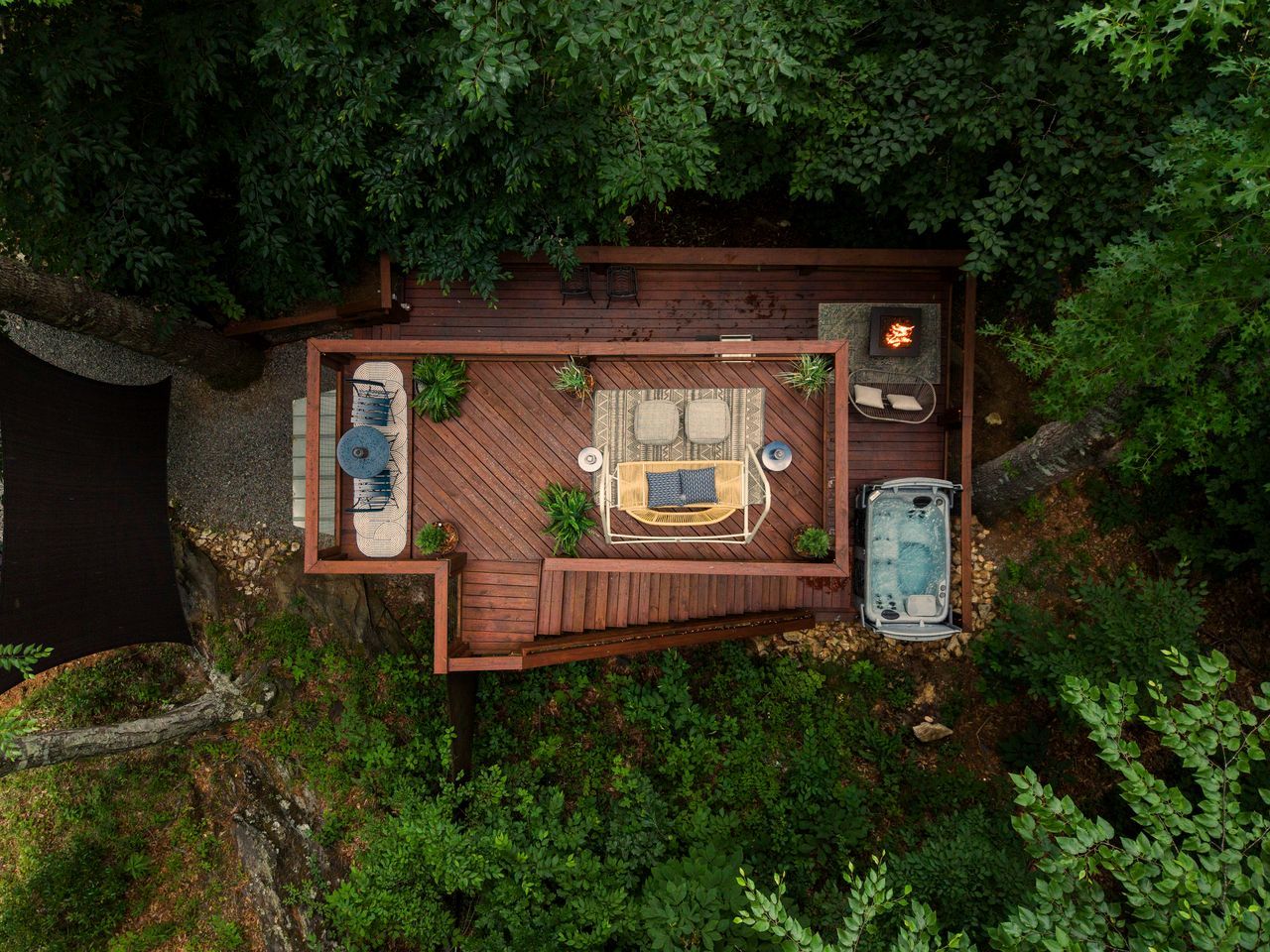 Una terraza con jacuzzi, zona de estar y un brasero.