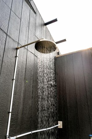 A modern outdoor shower with a circular basin and a vertical water flow. - Escape to the Stars: Bell Tent Getaway for Couples in Michigan's Idyllic Destination (Boyne Falls)