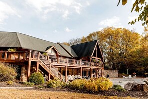 A lodge with a stone foundation, wooden deck, and multiple balconies.