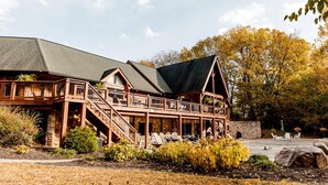 A lodge with a stone foundation, wooden deck, and multiple balconies.