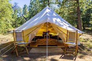 A dome-shaped tent with a central sleeping area, two chairs, and a small table with a lamp. - Pioneering Pet-Friendly Glamping: Mt. Laguna's Original Nature Lovers' Retreat (Mount Laguna)