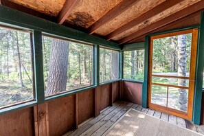 A cabin with wooden walls and large windows, offering views of a forested area. - Charming Pet-Friendly Cabin in Ely, Ideal for Getaways to Nature in Minnesota (Ely)
