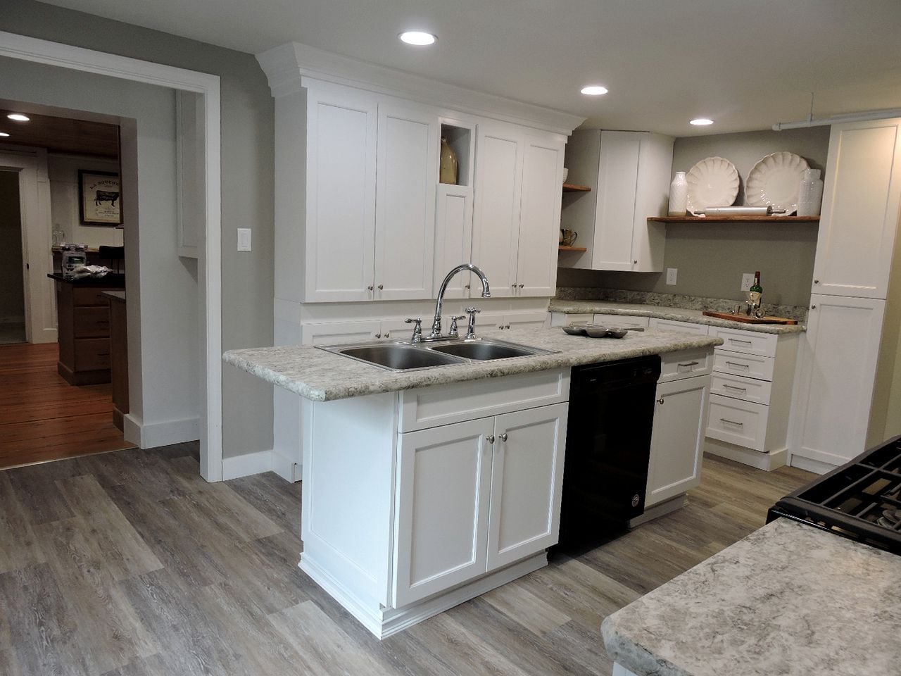 A kitchen with white cabinetry, a double sink, and a dishwasher.