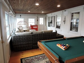 A cozy room with a pool table, wicker furniture, and a Coca-Cola cooler. - Cabin Retreat for Nature and City Exploration near Sebago Lake State Park, ME (Casco)