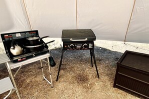 Una estufa de propano y un juego de parrilla Blackstone instalados al aire libre.