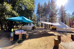 A campsite with tents, a picnic table, and a water dispenser.