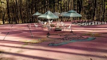 A park with a chessboard, outdoor seating, and a painted design.