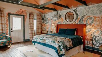 A bedroom with a bed, a chair, a door, and a wall with a swirl pattern.