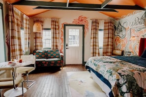 A room with a bed, a sofa, a dining table, and a chair. - Chic and Cozy: Romantic Glamping at Its Finest in Tennessee (Tracy City)