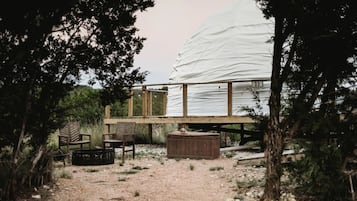 Eine Holzterrasse mit zwei Stühlen und einem Tisch, ein überdachter Außenbereich und ein Schild mit der Aufschrift 'D3'.