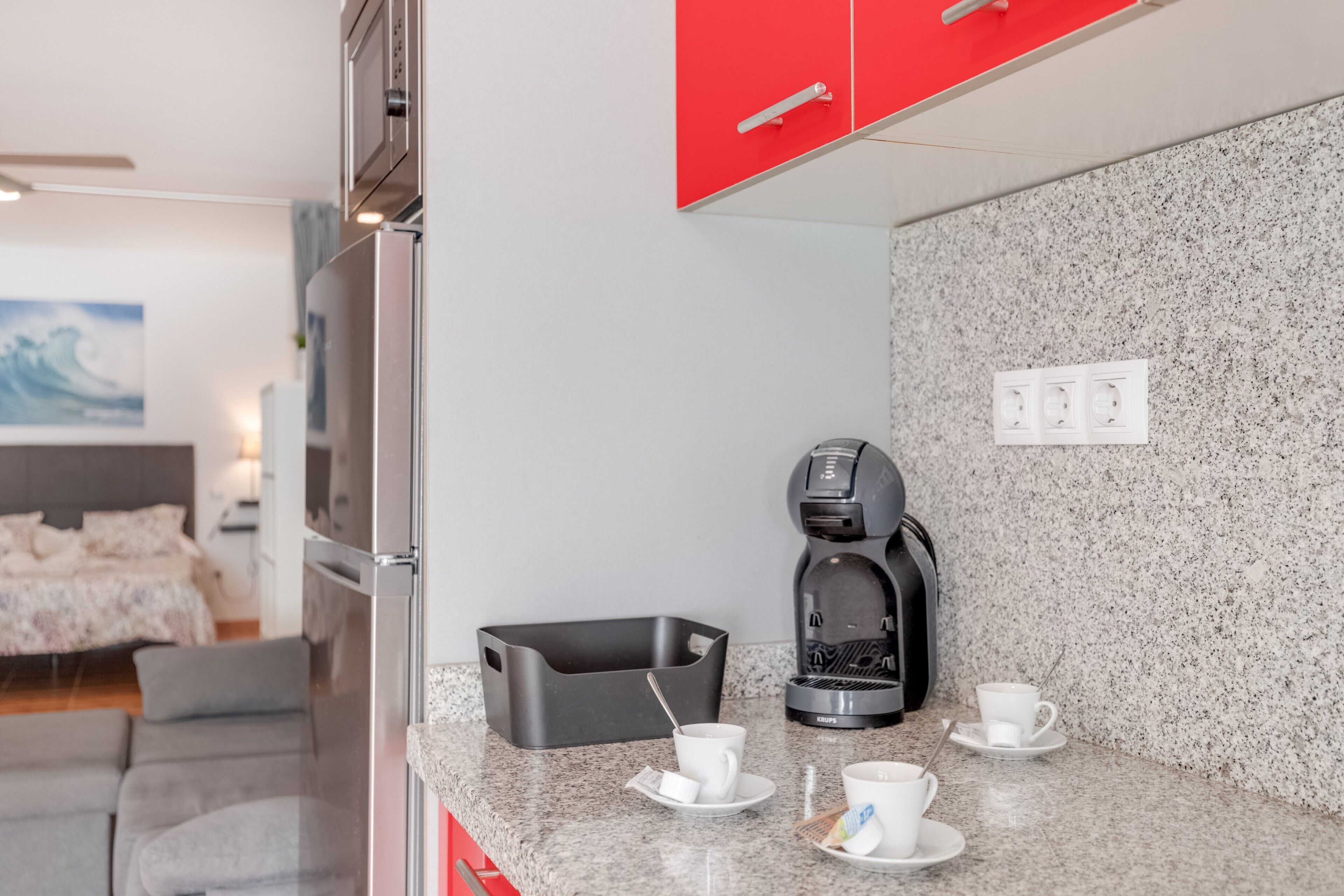 Une cuisine compacte équipée d’une machine à café, d’un grille-pain et d’un comptoir pour prendre le petit-déjeuner.