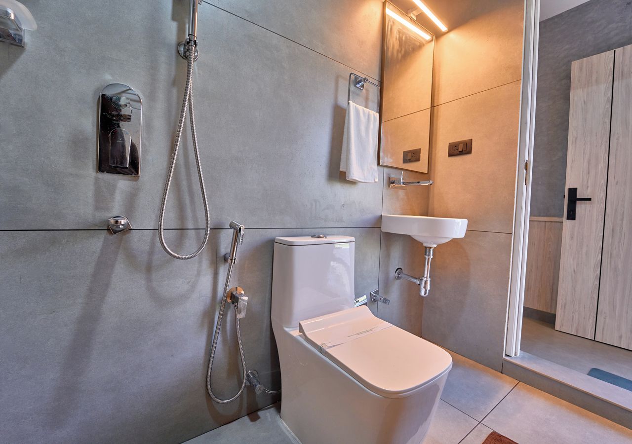 Une salle de bain moderne équipée de toilettes, d’une douche et d’un lavabo.