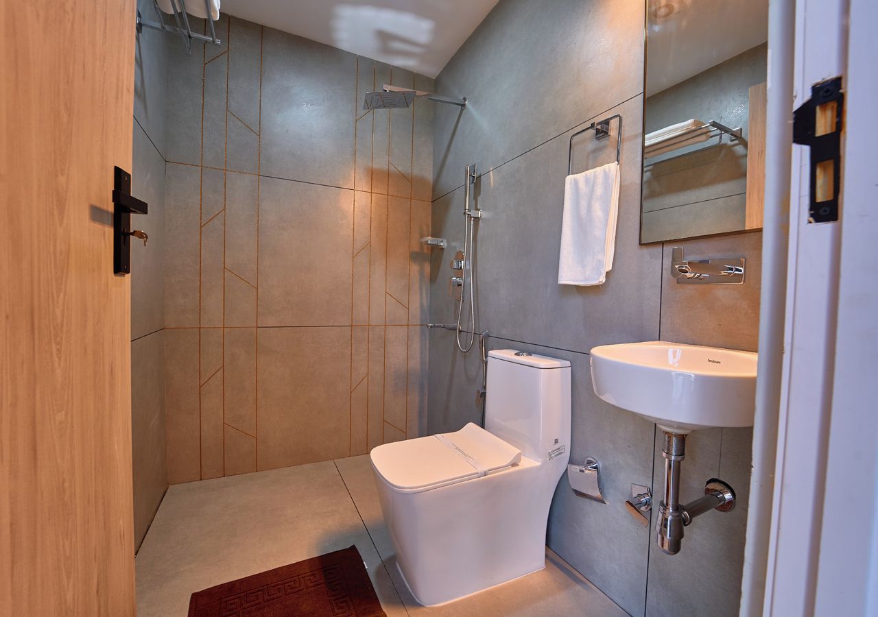 A modern bathroom with a shower, toilet, and sink.