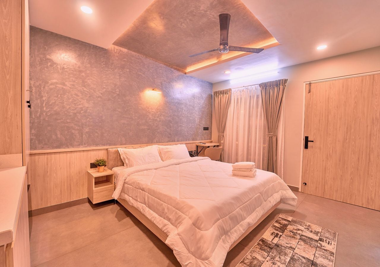 A modern bedroom with a bed, bedside table, and a ceiling fan.