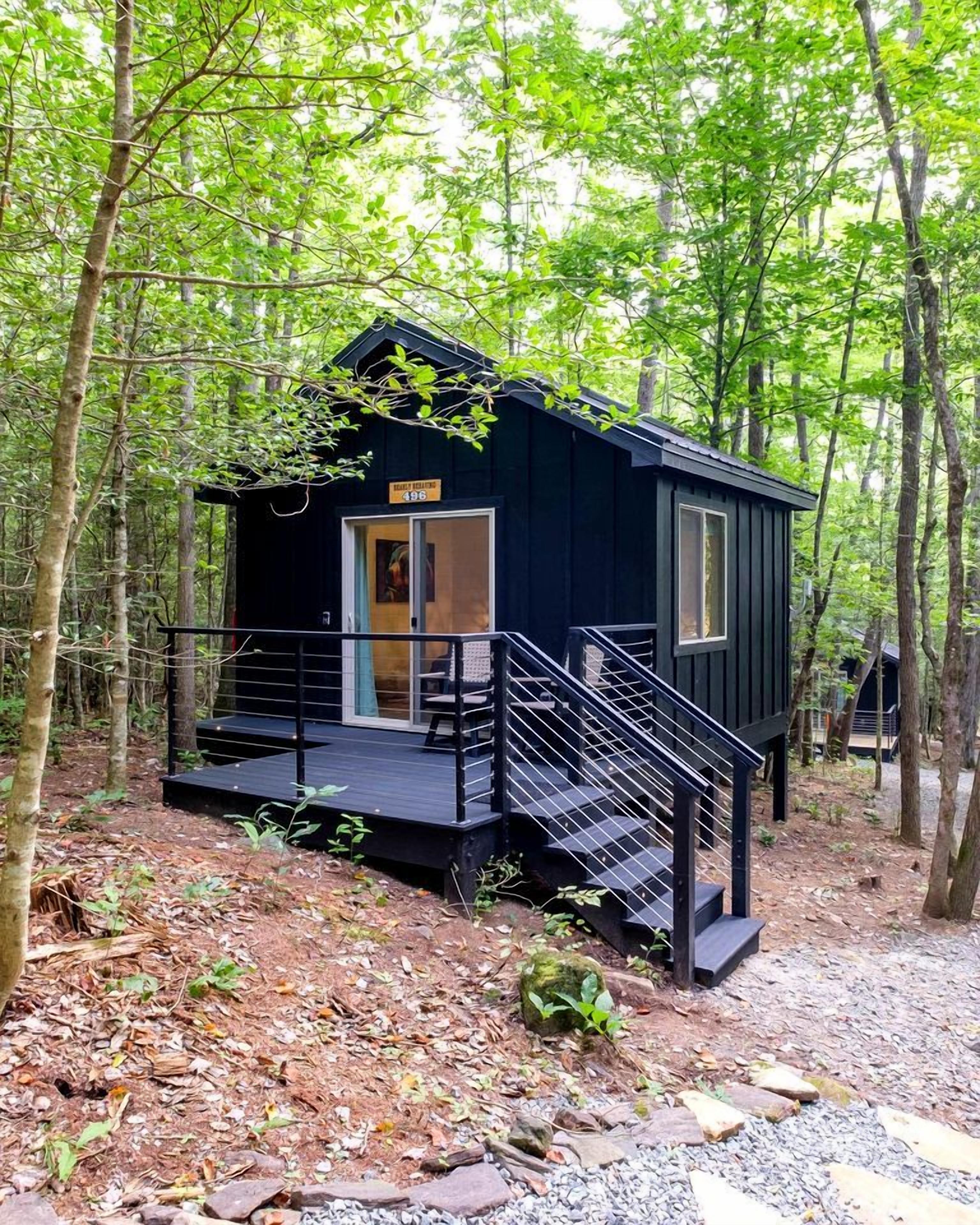 Eine kleine Holzhütte mit einer Holzterrasse und einer Treppe zum Eingang.