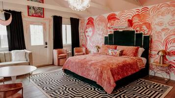 Ein Schlafzimmer mit einem großen Bett, einer Couch, einem kleinen Tisch und einem Stuhl.