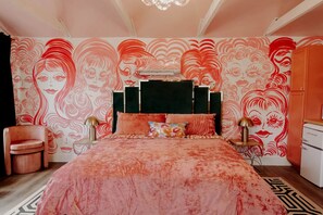 Ein Schlafzimmer mit einem großen Bett, einem Sessel, einem Nachttisch und einer Kommode.