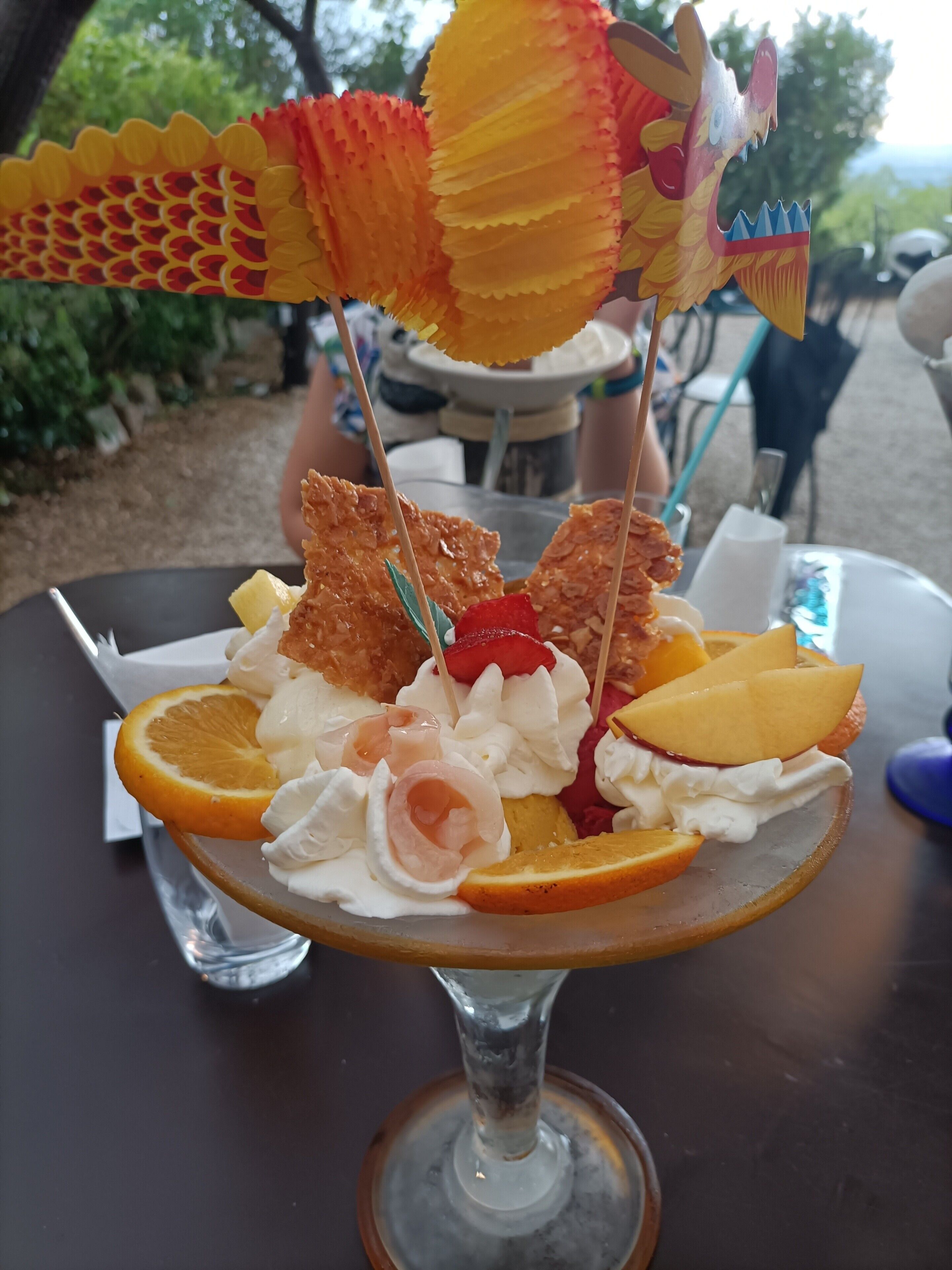 Un postre con fruta y una decoración de dragón sobre una mesa.