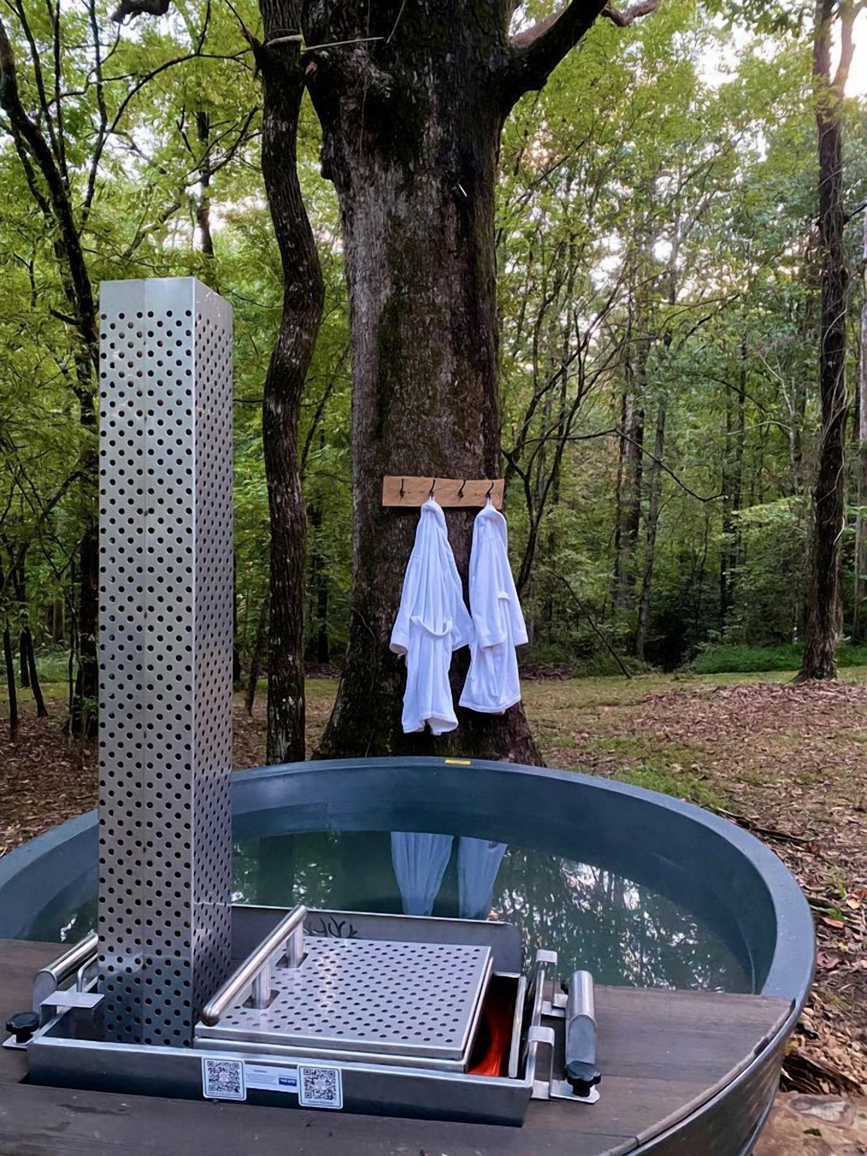 A hot tub with a metal frame, a wooden bench, and a metal platform.