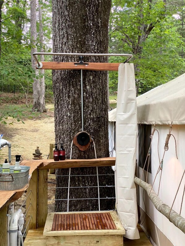 A treehouse with a wooden bench, a hanging basket, and a metal railing.