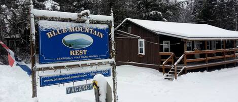 A Blue Mountain Rest sign with a cabin in the background.
