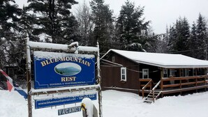 A Blue Mountain Rest sign with a cabin in the background. - Cozy Cabin Getaway in the Adirondack Mountains in Blue Mountain Lake, New York (Indian Lake)