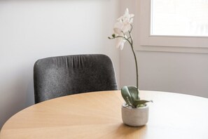A round wooden table with a potted plant on it. - Ceuta Apartment | Charming Balcony Overlooking Porto's Rooftops   (Porto)