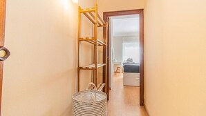 A narrow hallway with a wooden door frame, a metal rack, and a striped basket. - Your Home in the Heart of Zaragoza (Zaragoza)