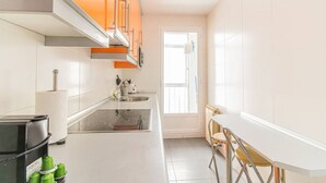 A modern kitchen with a central island, a built-in oven, and a window providing natural light. - Your Home in the Heart of Zaragoza (Zaragoza)