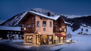 A two-story wooden building with a balcony, large windows, and a snow-covered mountain backdrop. - Chalet Layla by Original Galli (Livigno)
