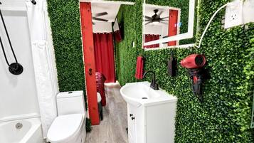 A bathroom with a white toilet, a sink, and a shower area.