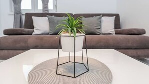 A modern living room with a white coffee table, a geometric metal stand, and a potted plant. - Star house 1 (Novalja)