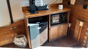 Une petite cuisine équipée d’une machine à café, d’un four à micro-ondes et d’un petit réfrigérateur.