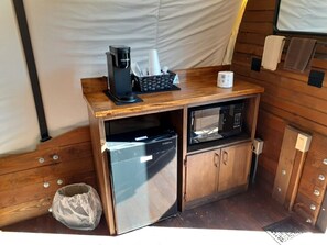 Une petite cuisine équipée d’une machine à café, d’un four à micro-ondes et d’un petit réfrigérateur.