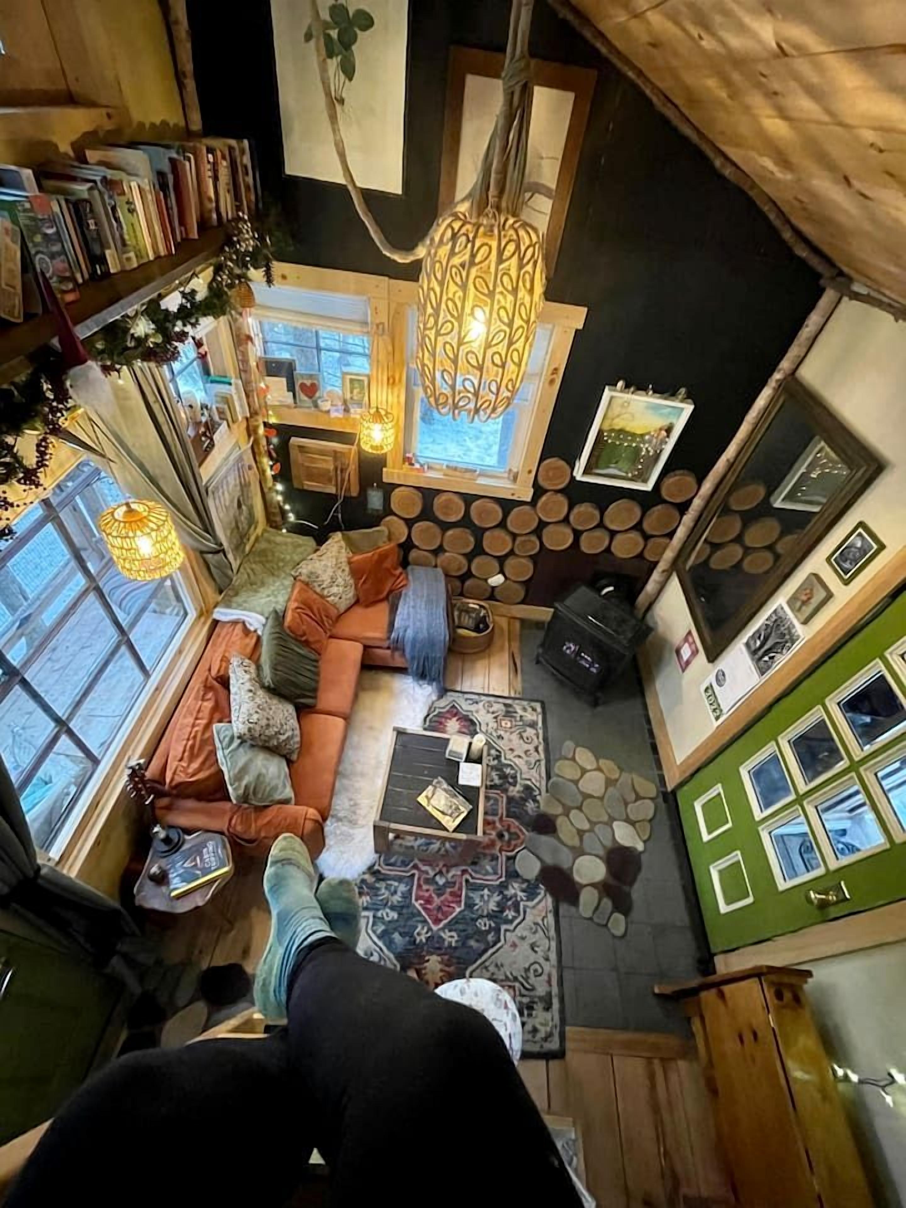 A cozy room with a sofa, a coffee table, a fireplace, and a bookshelf.