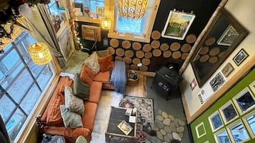 A cozy room with a sofa, a coffee table, a fireplace, and a bookshelf.