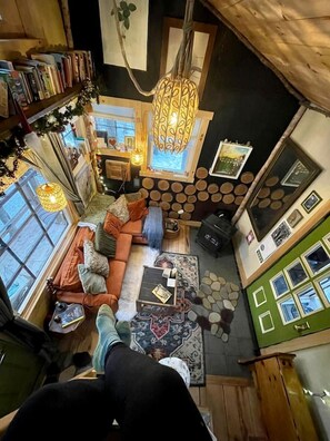 Un ambiente accogliente con divano, tavolino, camino e libreria.
