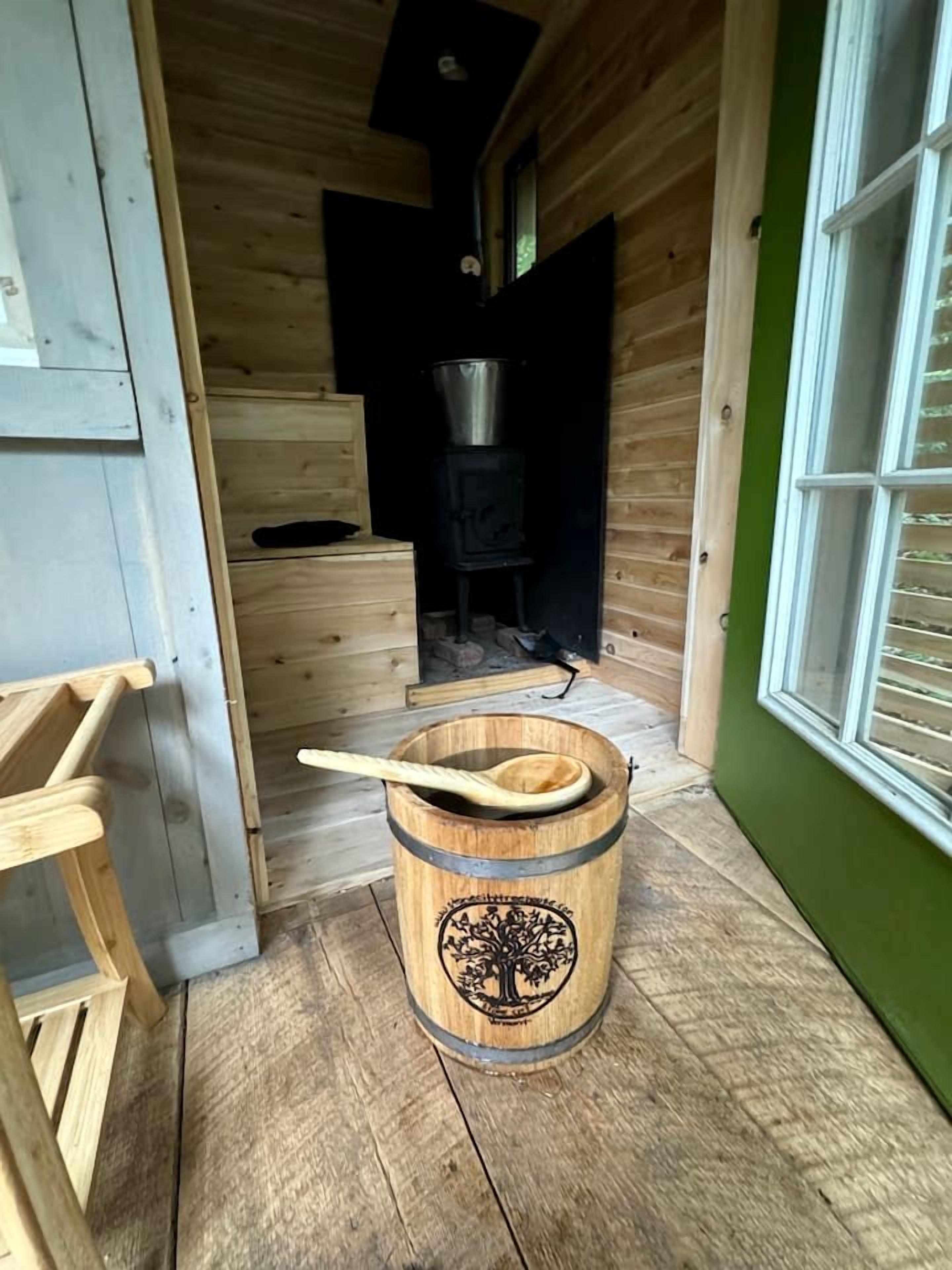A wooden interior with a wooden barrel, a wooden spoon, and a stove.