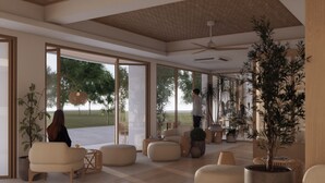 Amplia sala de estar con ventanas grandes, ventilador de techo y diferentes disposiciones de asientos.